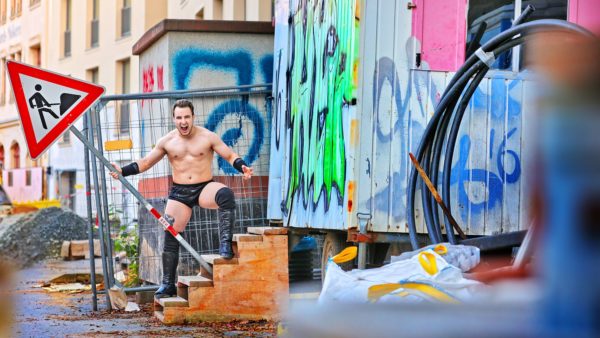 Wrestler Laurenz Domschke mit Bauarbeiterschild auf der Prießnitzstraße - Foto: Amac Garbe