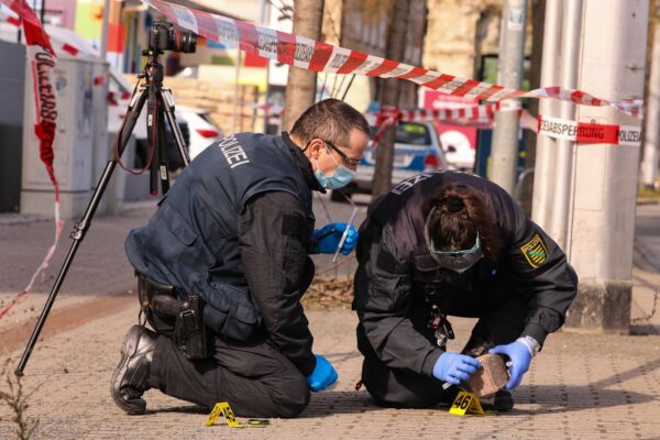 Kriminalisten bei der Spurensuche am Tatort. Pflastersteine werden auf DNA untersucht. Foto: Tino Plunert