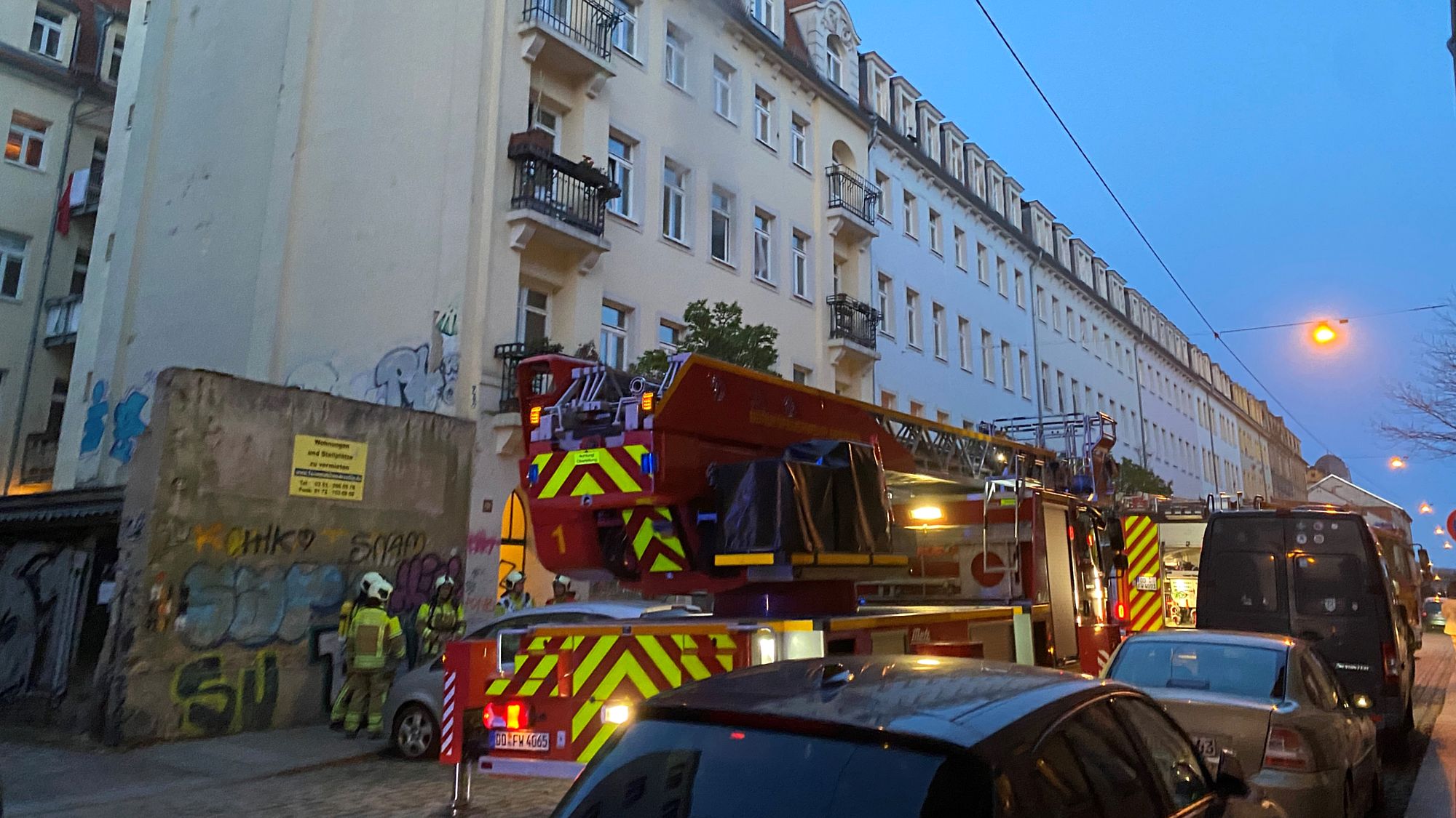 Einsatzfahrzeuge und Einsatzkräfte vor Wohnhaus in der Sebnitzer Straße. Rauch aus Fenster sichtbar. Foto: Feuerwehr Dresden