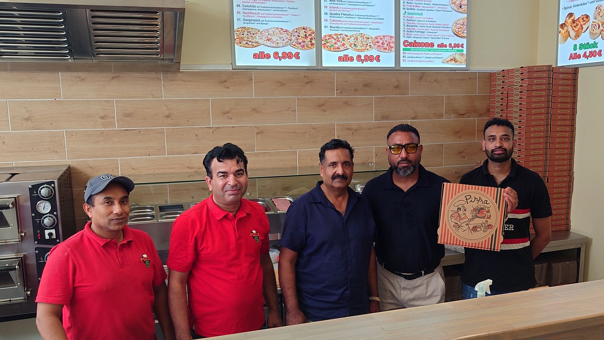 Khalid Riaz Mazhar mit seinem Team in der neuen Filiale auf der Rothenburger Straße. 