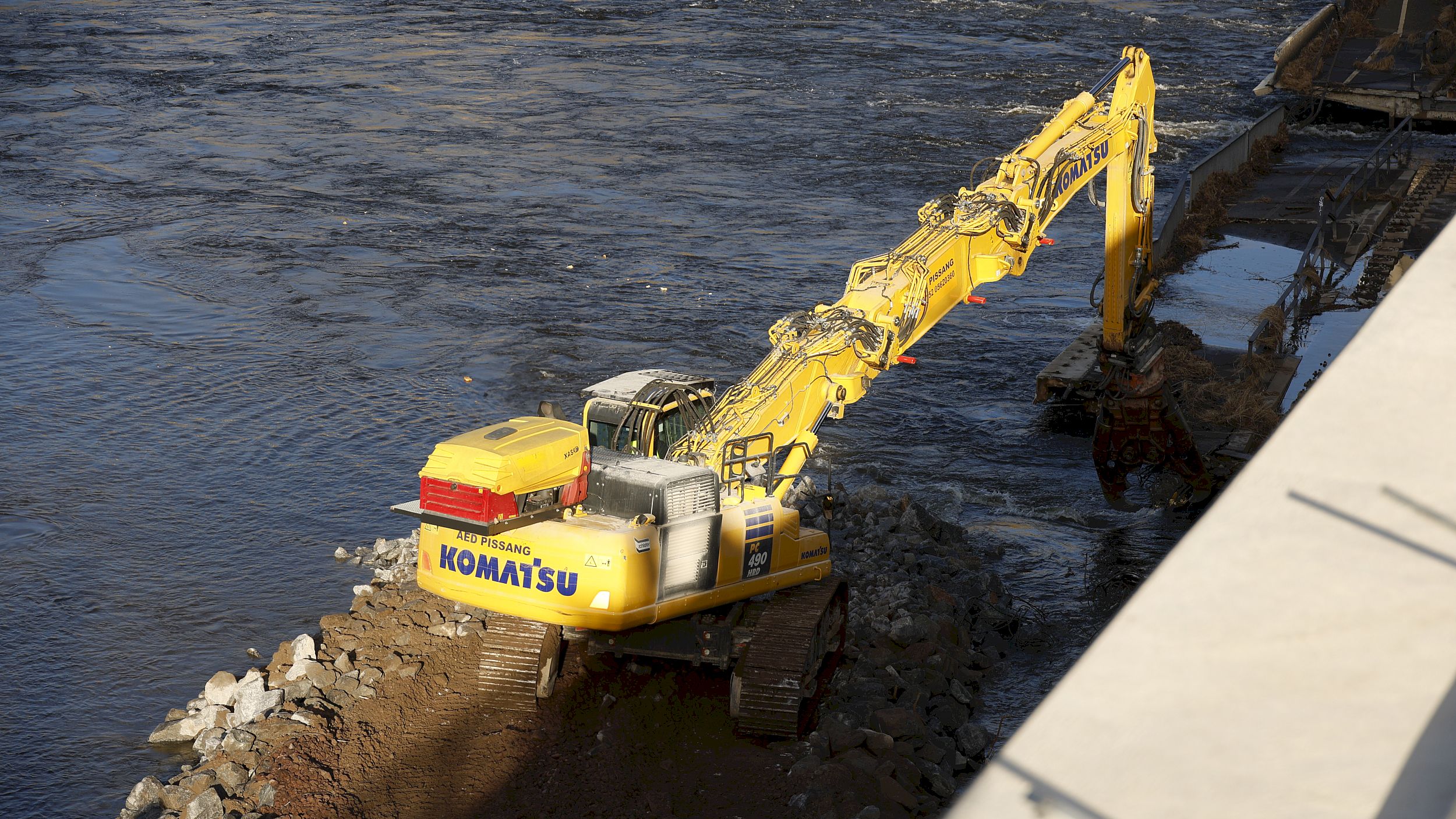 Auf einer Art Baustraße fährt der Bagger in die Elbe, um weitere Teile der Brücke abzutragen. Foto: Florian Varga