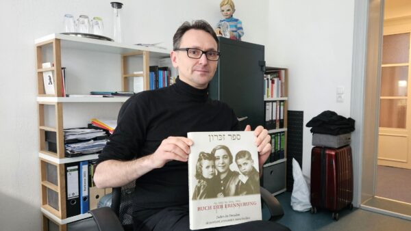 Projekttheater-Vorstand Dirk Strobel mit dem Buch der Erinnerung. Juden in Dresden: Deportiert, ermordet, verschollen. Foto: Anton Launer